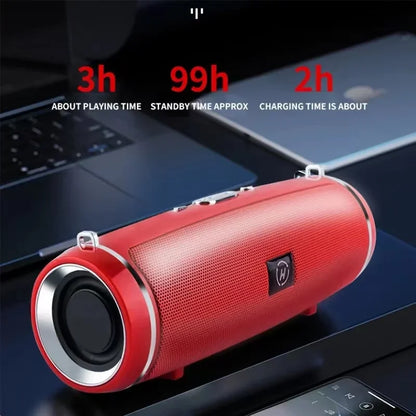 Enceinte Bluetooth rouge cylindrique sur bureau avec ordinateur portable, autonomie 3h lecture, charge 2h