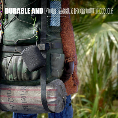 Haut-parleur portable noir accroché à un sac à dos de randonnée vert en extérieur