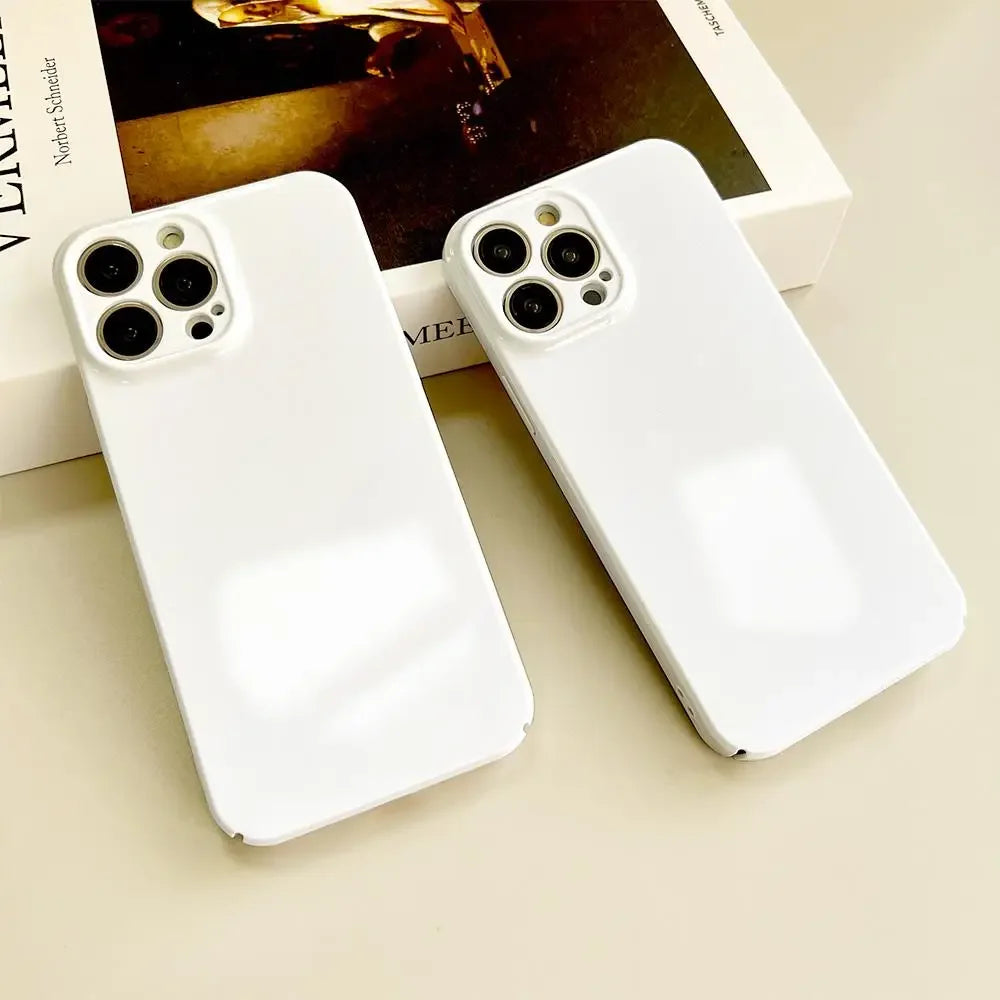 Deux coques blanches protégeant des smartphones avec triple caméra, posées sur un livre