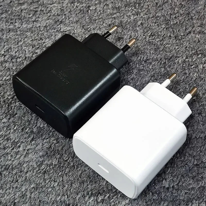 Deux chargeurs secteur USB de couleur noire et blanche avec prise européenne sur fond gris