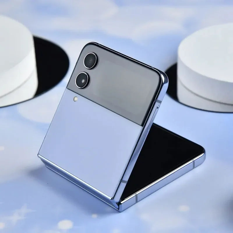 Smartphone pliable moderne argent avec double caméra arrière sur fond bleu avec objets blancs