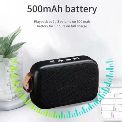 Enceinte Bluetooth portable noire avec batterie 500 mAh et contrôle volume, près d'un clavier et plante décorative