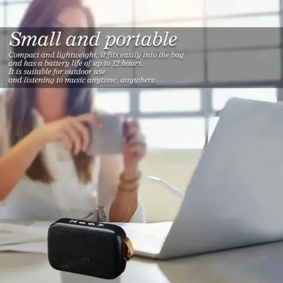 Enceinte Bluetooth portable noire devant un ordinateur portable, idéale pour écouter de la musique partout