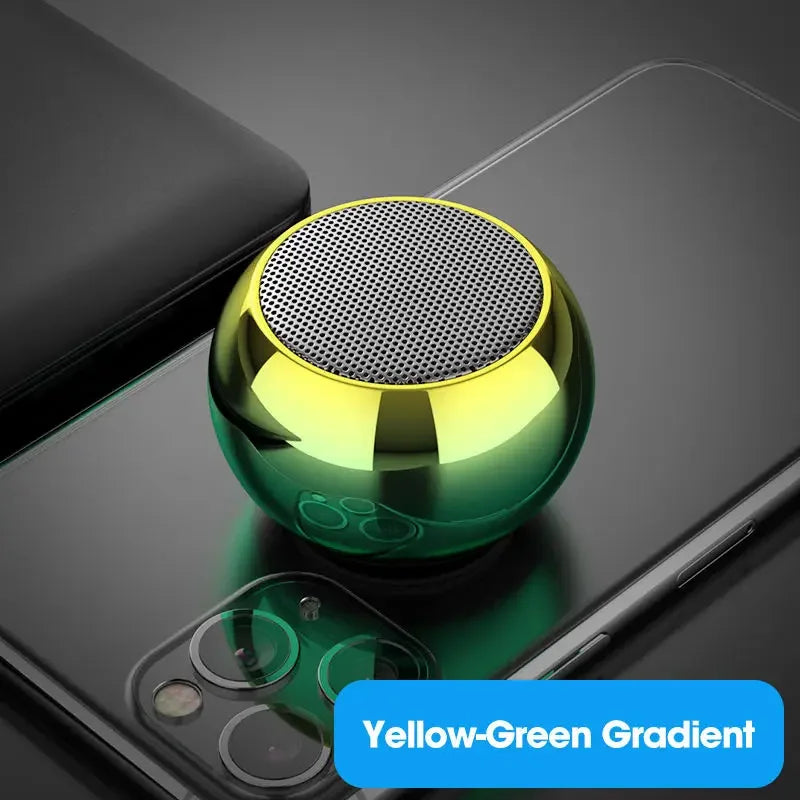 Haut-parleur portable jaune-vert dégradé posé sur un smartphone noir avec couverture noire