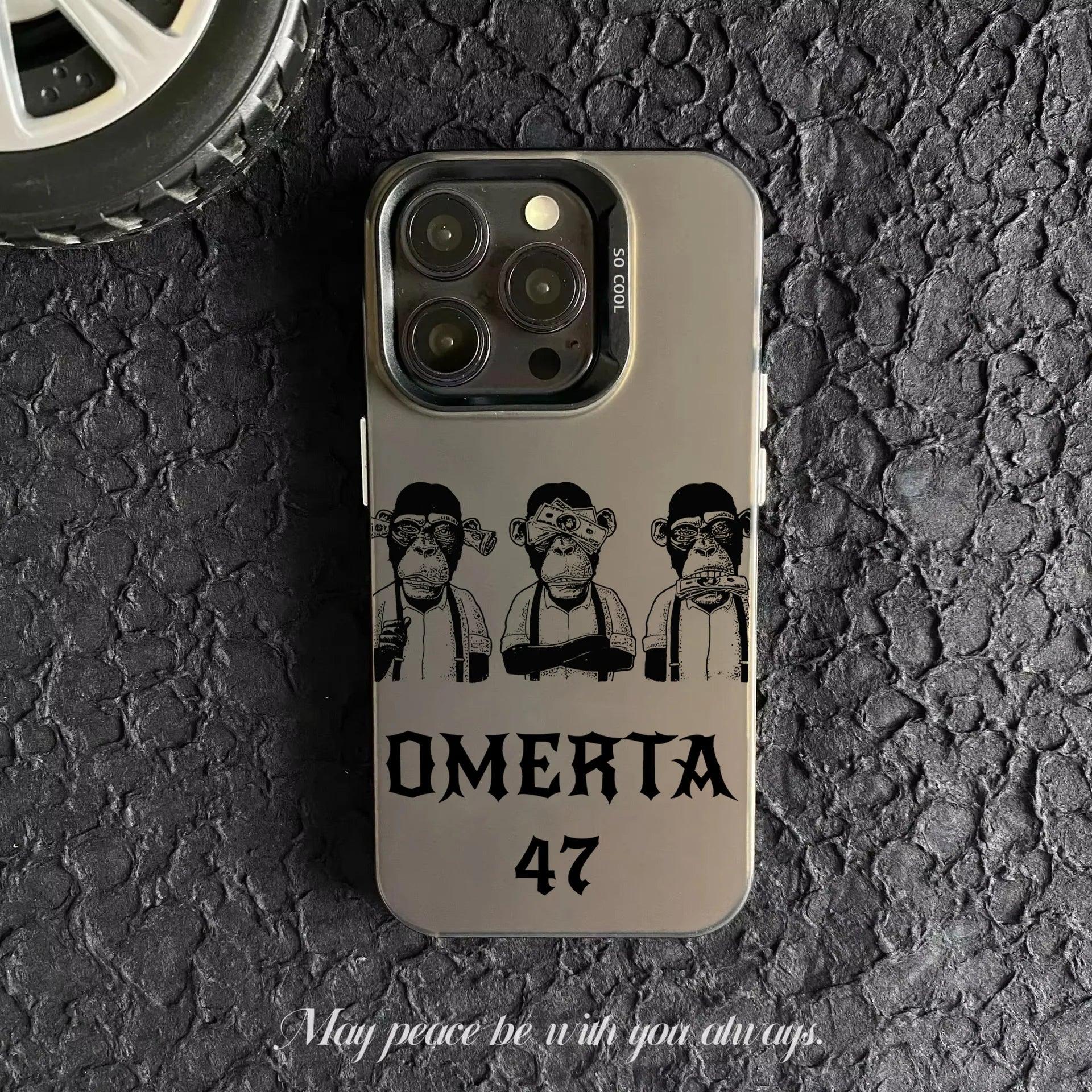 Coque de téléphone gris avec illustration de trois singes stylisés et texte Omerta 47 sur fond asphalté