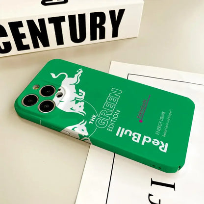 Coque de téléphone verte Red Bull édition Green avec logo taureau blanc sur bureau beige