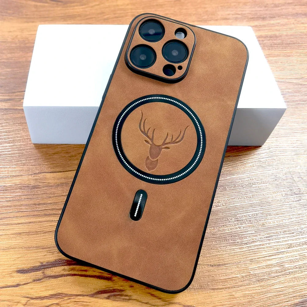 Coque de téléphone marron en cuir avec motif de tête de cerf, posée sur une surface en bois