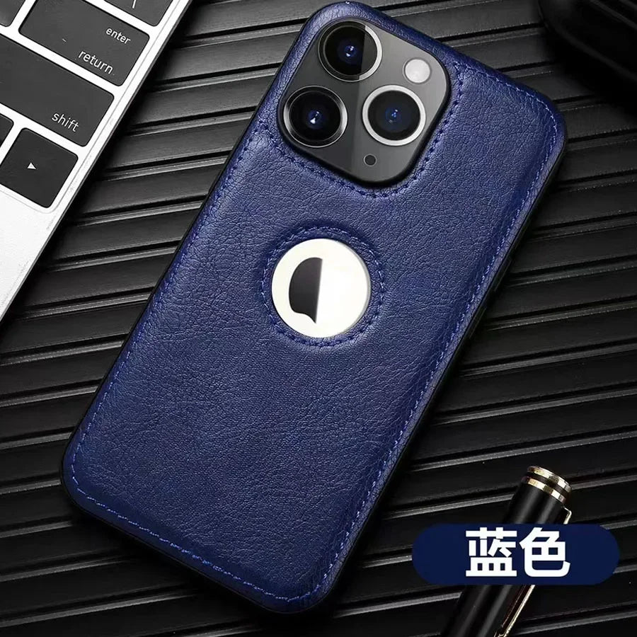 Coque de téléphone en cuir bleu avec triple caméra, posée sur surface noire, près d'un clavier et stylo