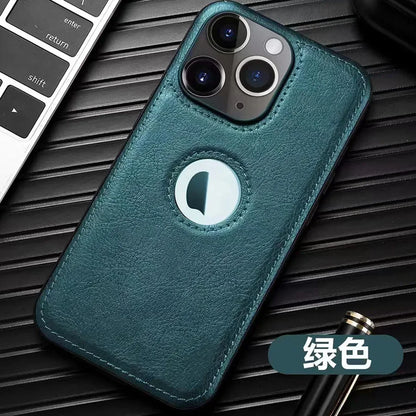 Coque de téléphone vert en cuir avec triple caméra sur fond noir à côté d'un clavier et stylo