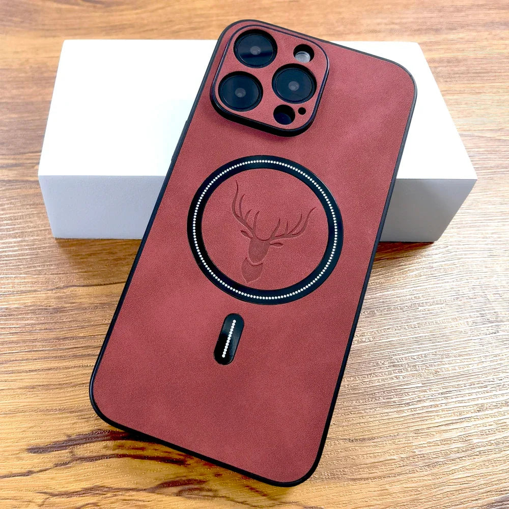 Coque de téléphone rouge en cuir avec motif tête de cerf, posée sur une boîte blanche et surface en bois